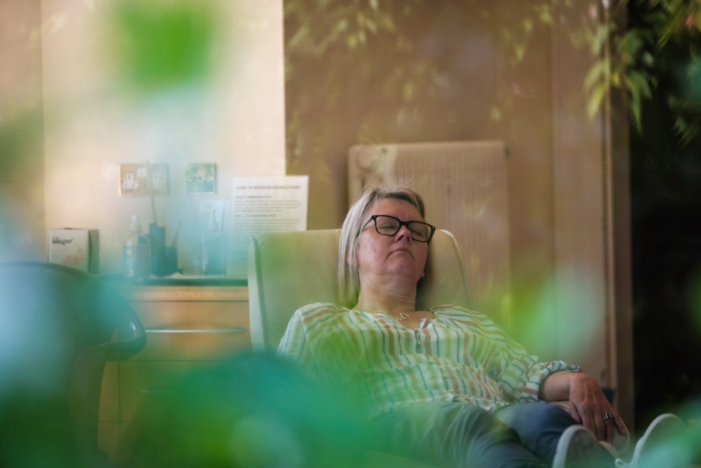 A woman relaxing in a comfortable chair on a wellbeing day at the Penny Brohn UK wellbeing centre.