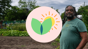 A photo of a black man with dreadlocks stood in an allotment
