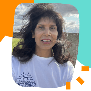 Almona, a woman of colour in her 50s, looks at the camera