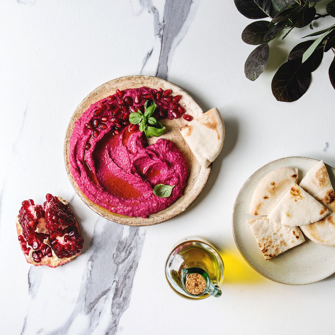 A plate of beetroot dip with bread on the side
