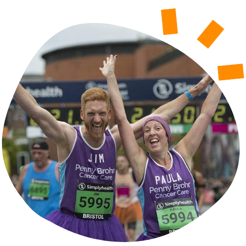 Man and woman with their hands in the air looking happy while running a race.
