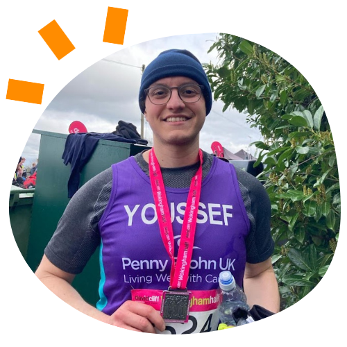 Photo of Yousef in a purple Penny Brohn UK running vest and a winners medal.