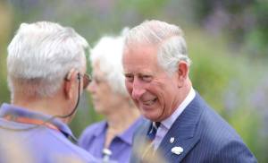 A photo of His Majesty King Charles III speaking and smiling with a Penny Brohn UK volunteer