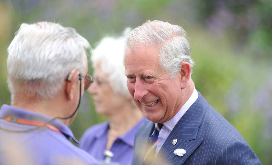A photo of His Majesty King Charles III speaking and smiling with a Penny Brohn UK volunteer
