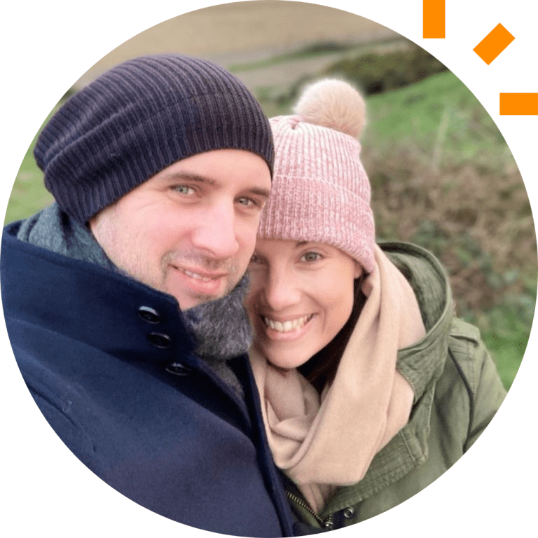 A picture of Amy and her husband standing outside